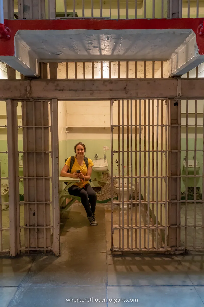 Woman sitting in an empty cell of Alcatraz prison during a night tour of the island