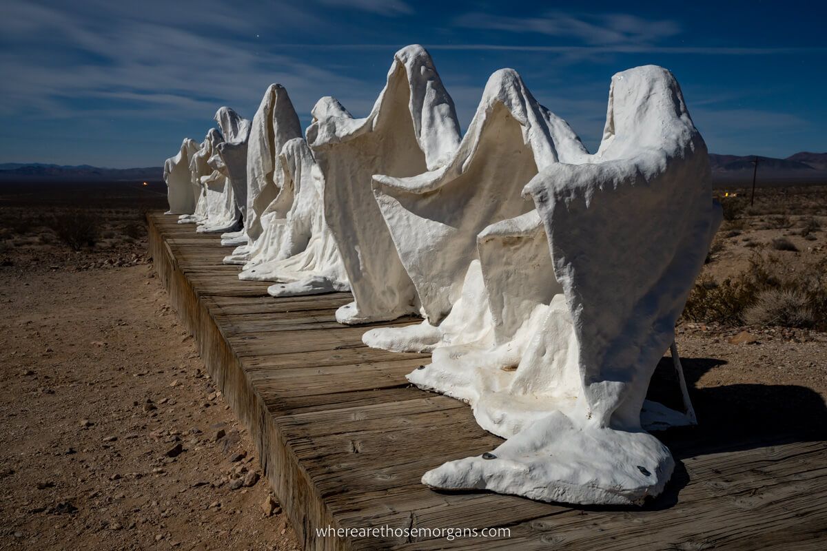 Long line of ghost statues illuminated by moonlight in Rhyolite near Death Valley