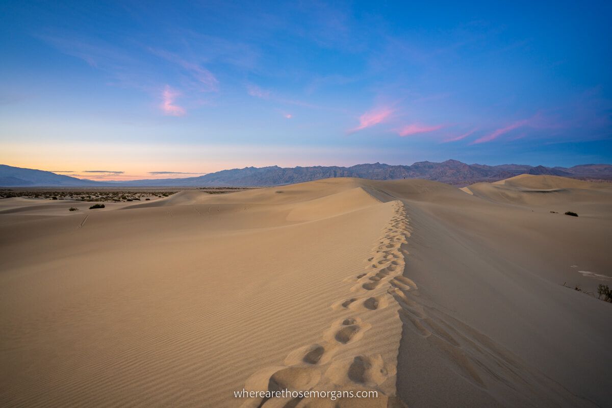 Footprints on top of sand dunes at Mesquite Flats in Death Valley National Park during sunset