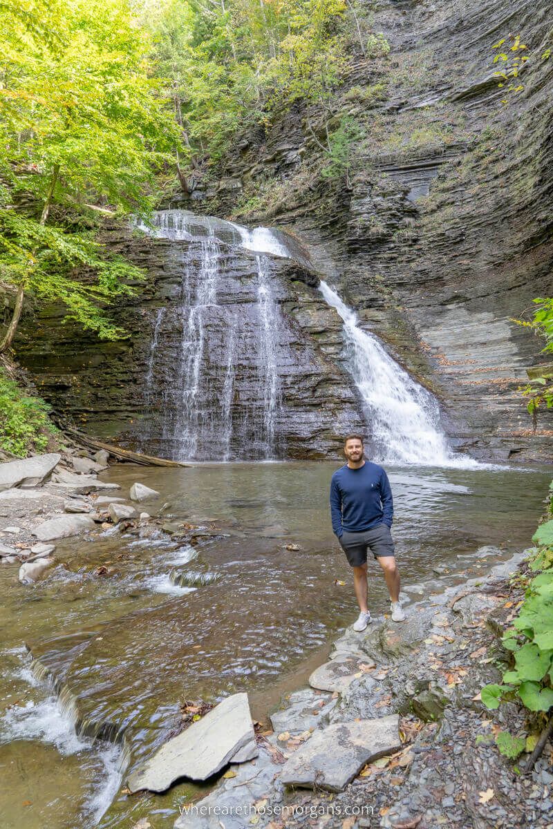 A hiker standing by a Grimes Glen Waterfall in the Finger Lakes region of New York state
