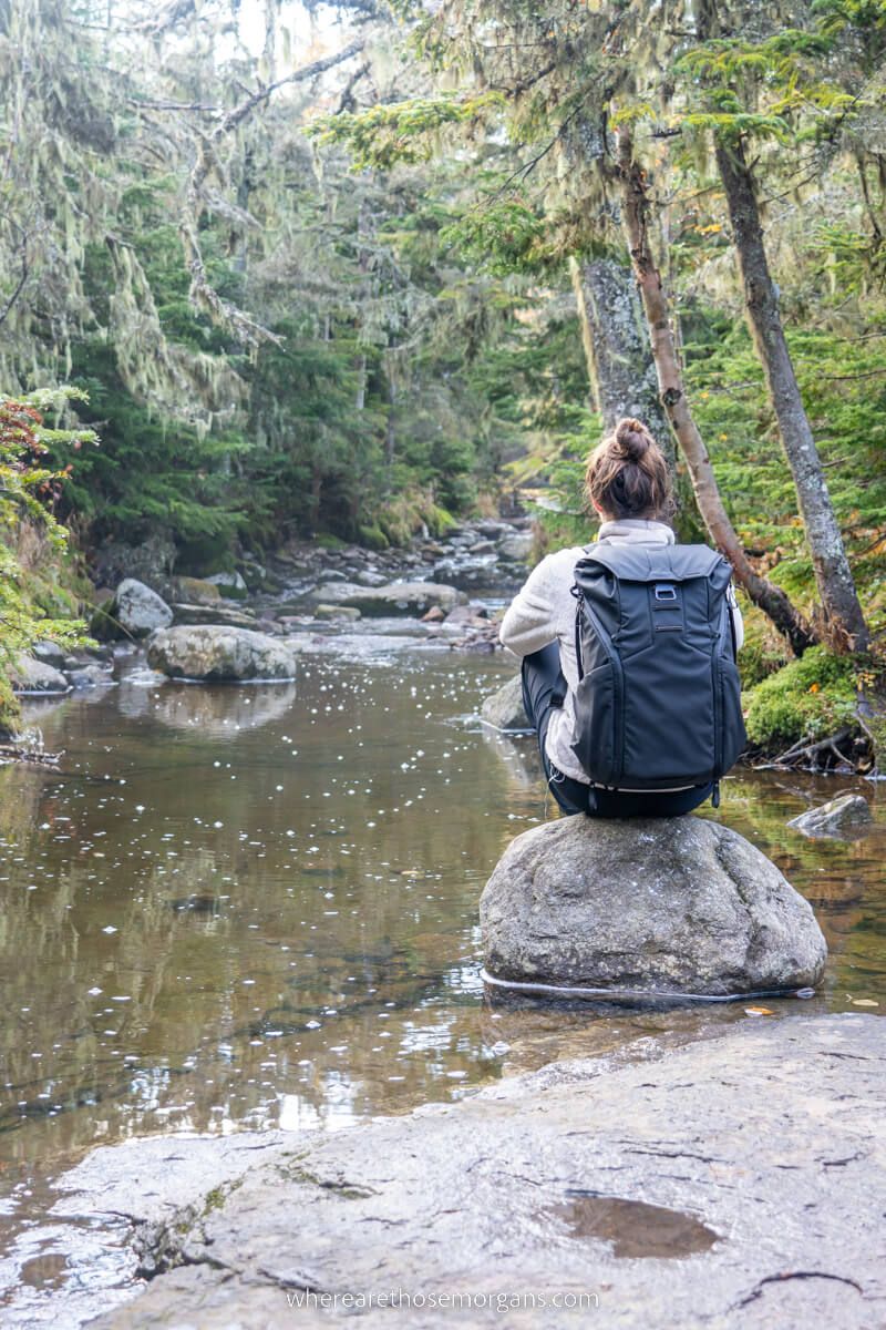 Woman sitting on a rock while day hiking in upstate New York