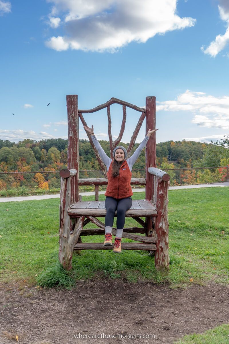 Woman sitting on large wooden chair near the Mount Morris Dam