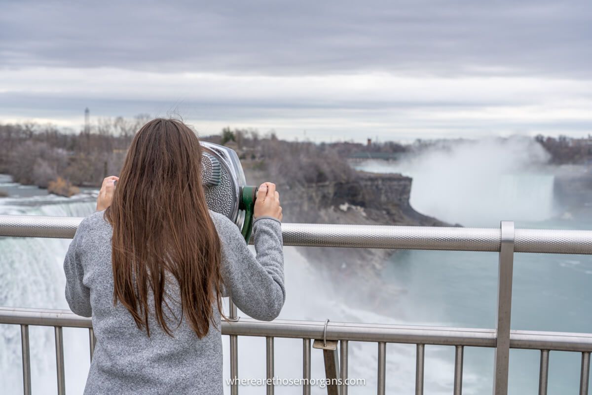 Woman looking through a viewfinder to see the American falls 