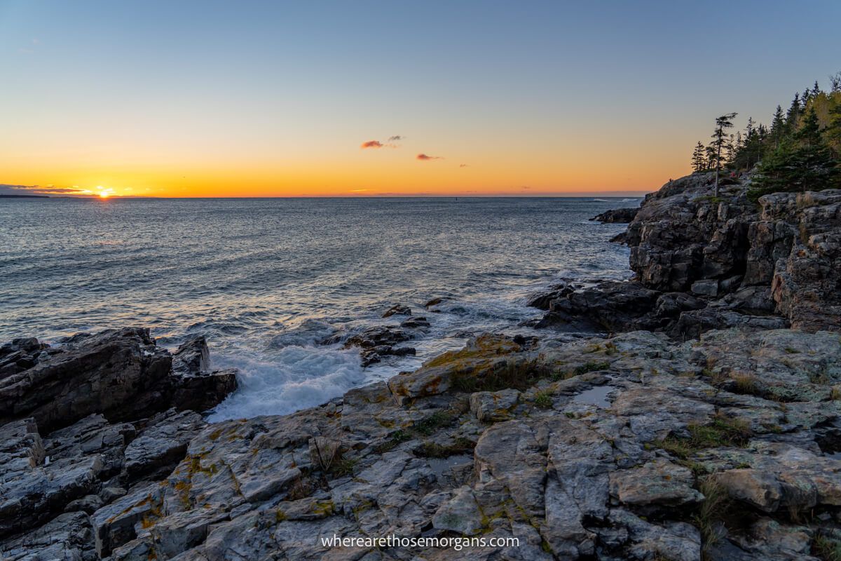 Sunrise over the ocean with water gently crashing onto rocks