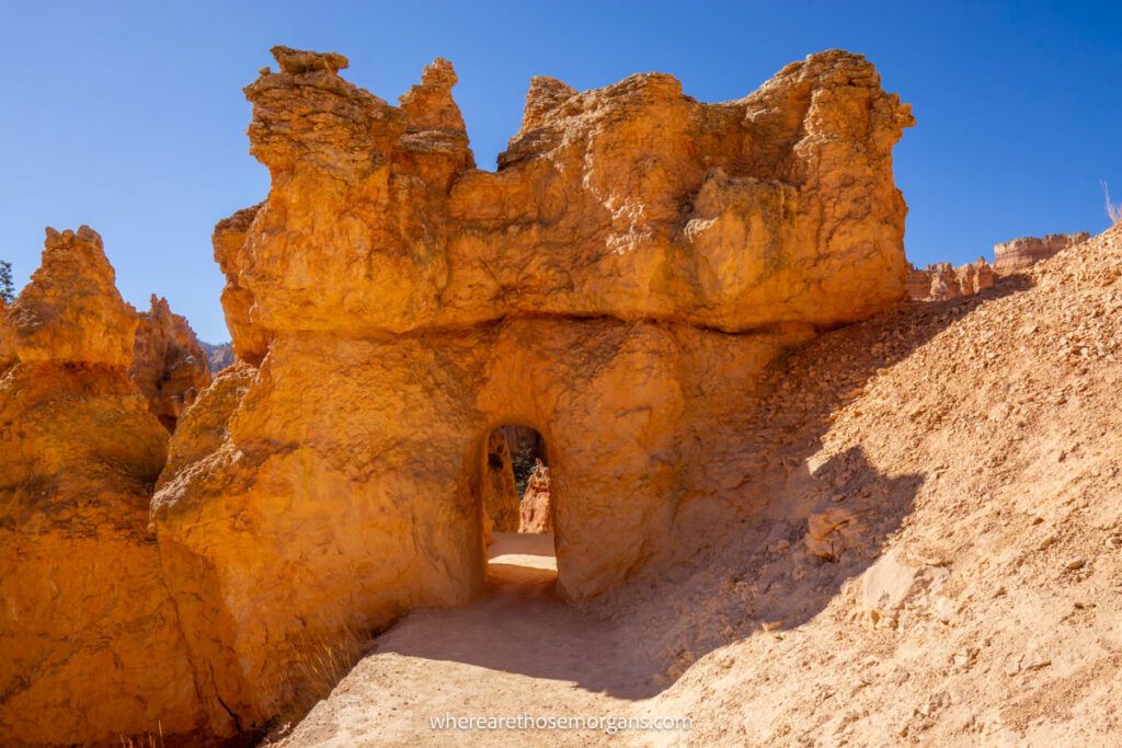 Doorway cut out of sandstone to create a hiking trail in a sunny sandy landscape