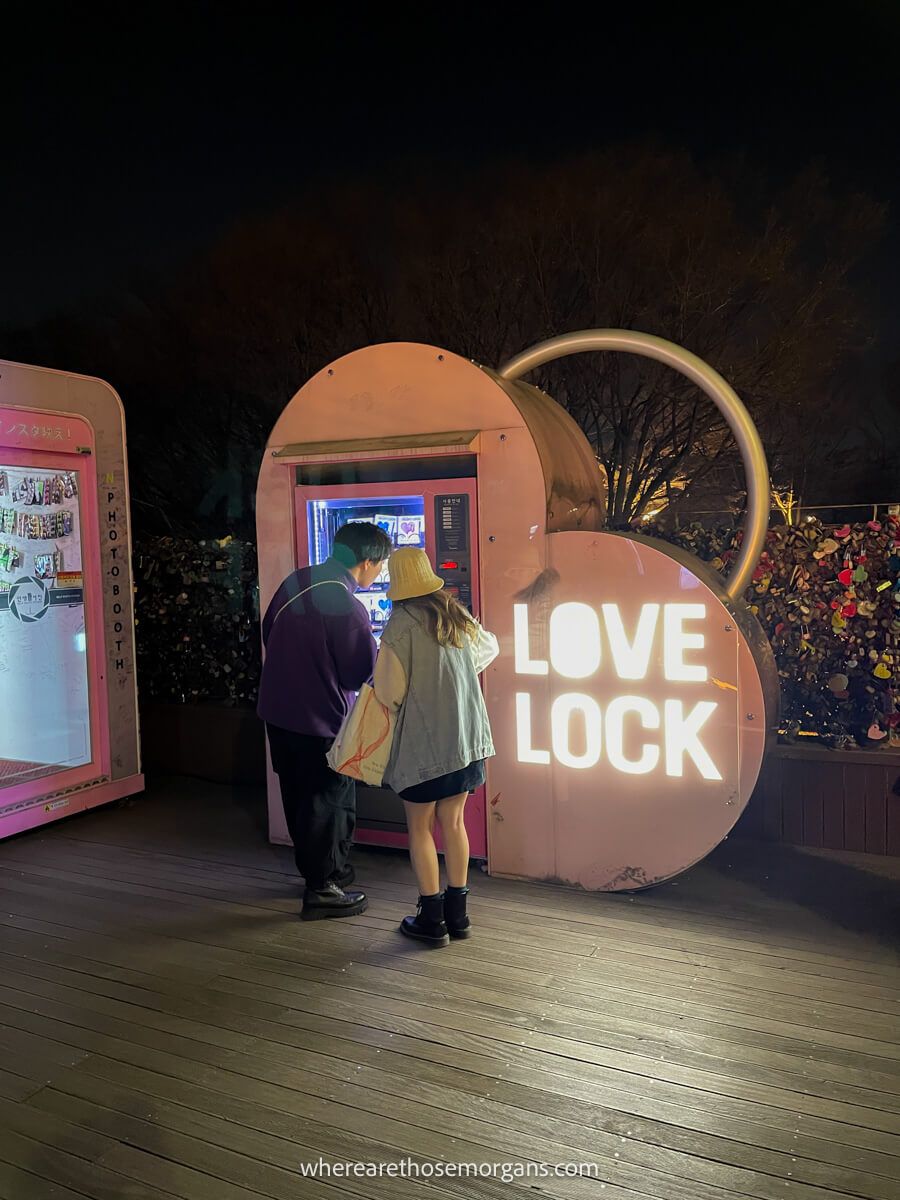 Two visitors buying a love lock for the proposal staircase