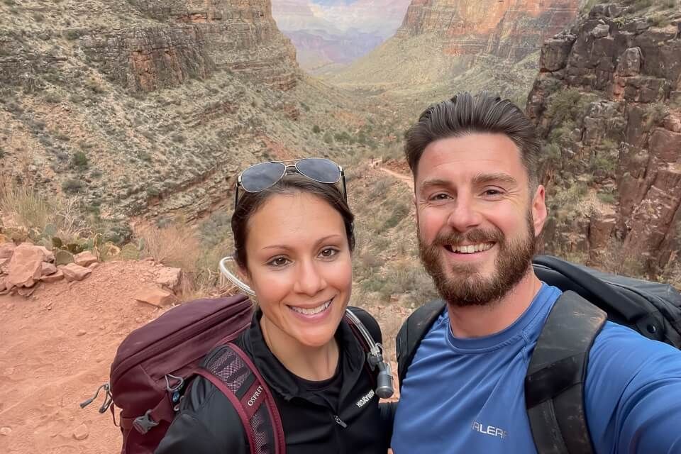 Man and woman taking a selfie on a hiking trail at Grand Canyon South Rim