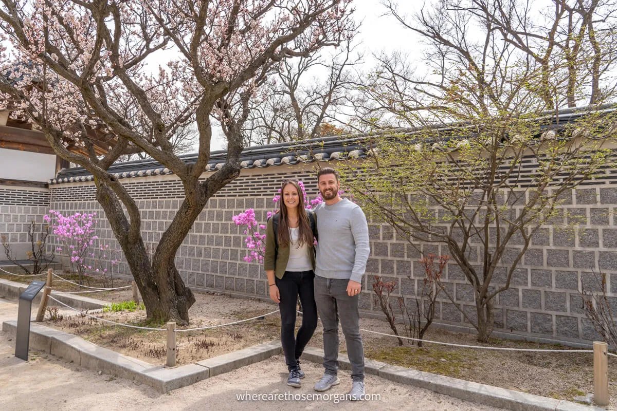 Two visitors posing for a photo inside the Gyeongbokgung Palace walls in Seoul