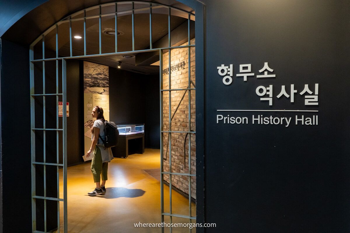 Woman reading a sign about the history of a prison in Seoul
