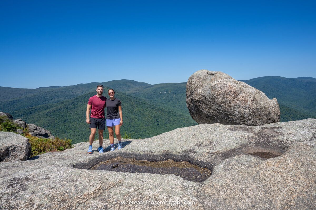 Couple standing together on a rocky summit in Shenandoah with clear blue skies