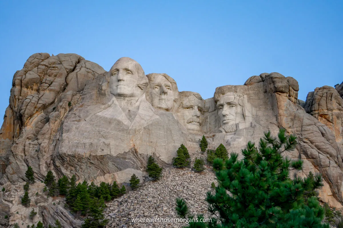 Granite mountain with caved faces dull grey in twilight with a deep blue sky behind