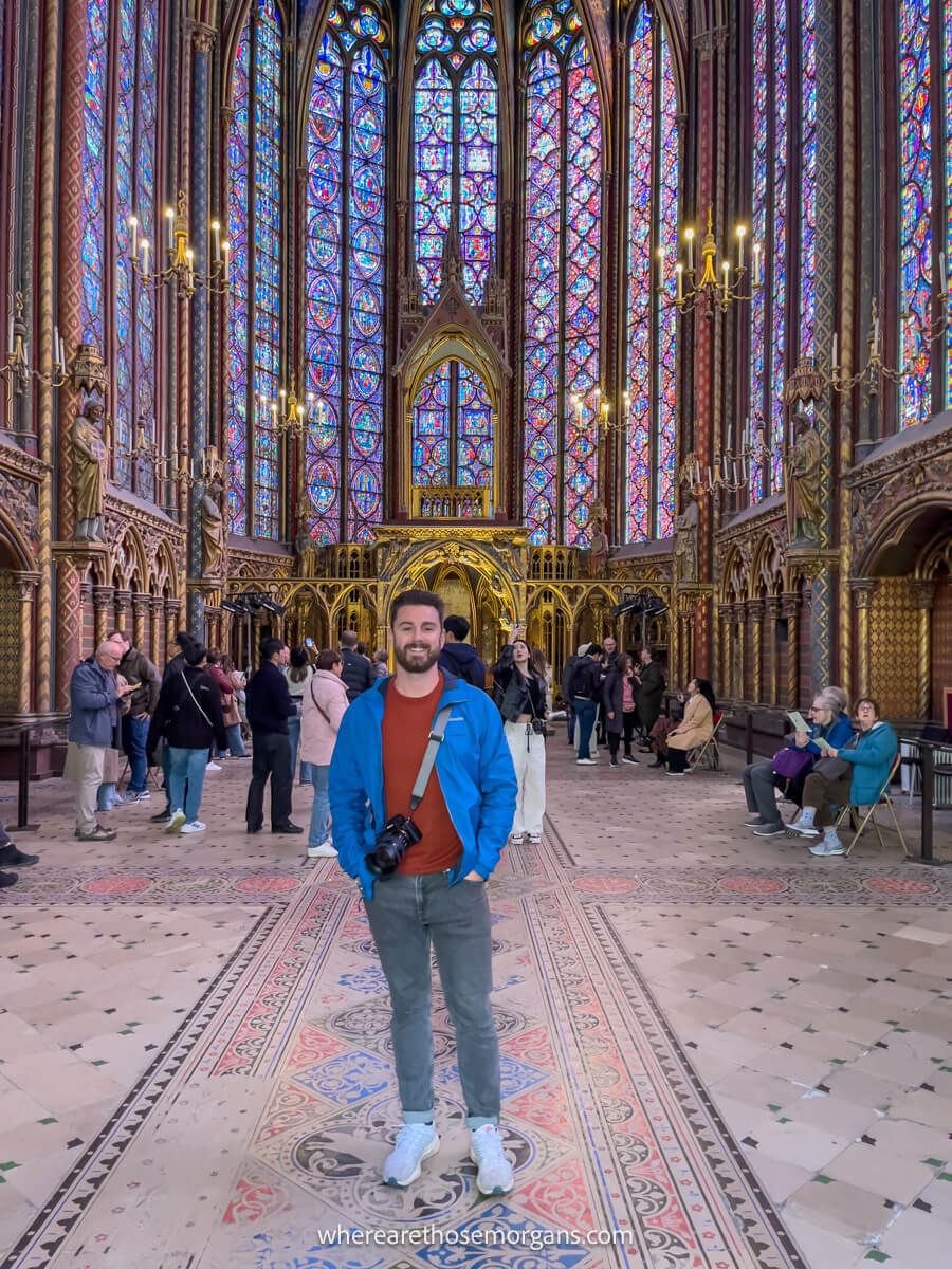Tourist taking a photo with the large glass windows inside Sainte-Chapelle