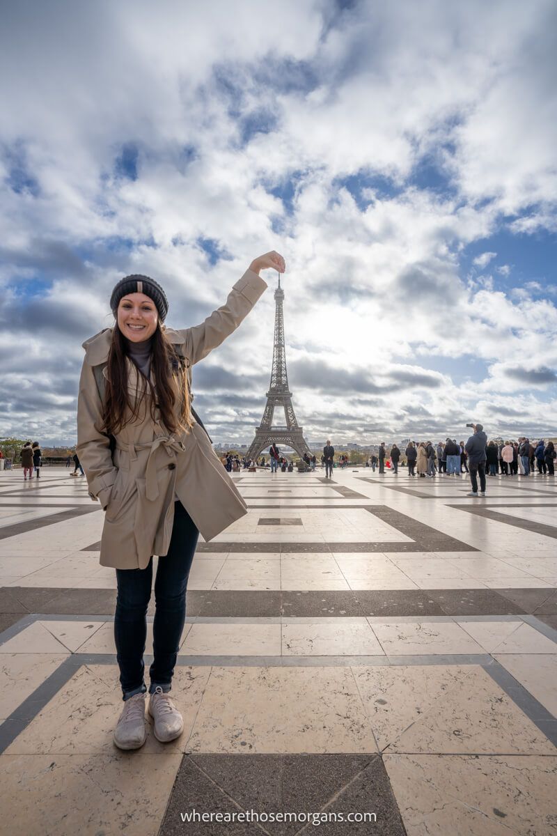 Tourist grabbing the top of the Eiffel Tower perspective photo from Trocadero in Paris