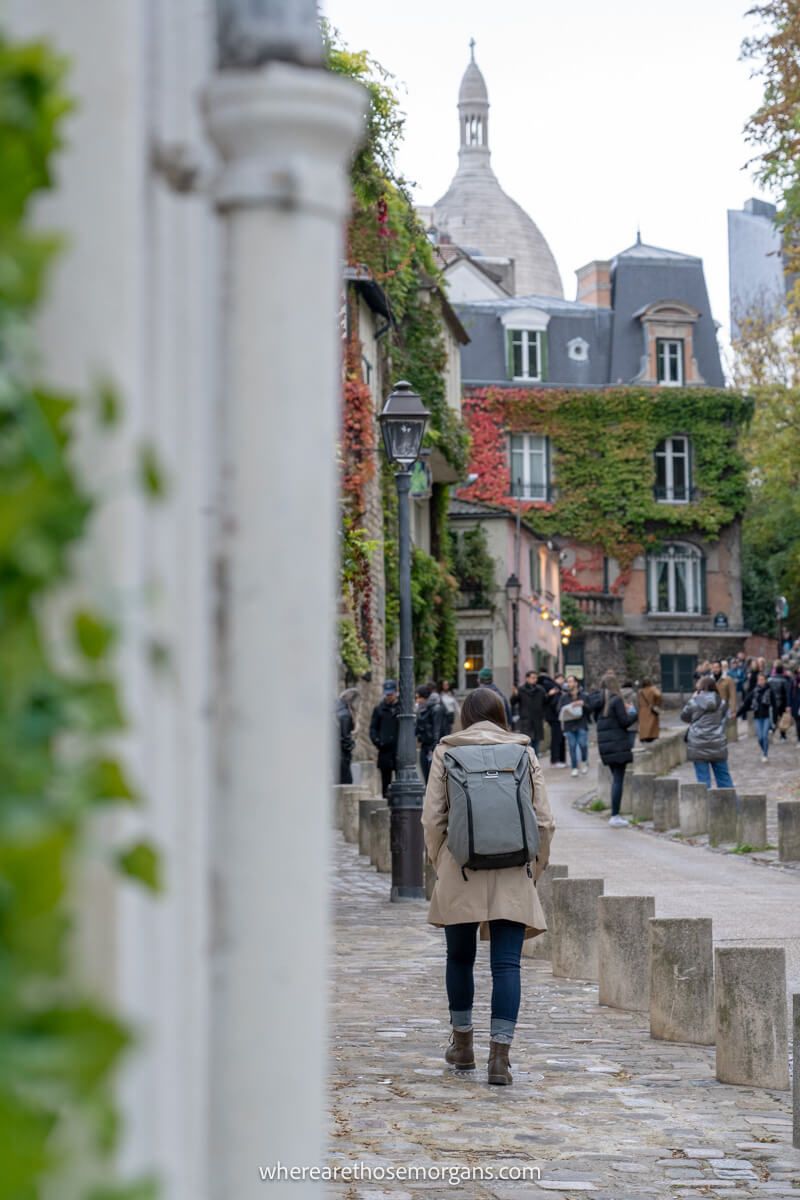 Tourist walking down cobbled streets in Montmartre Paris