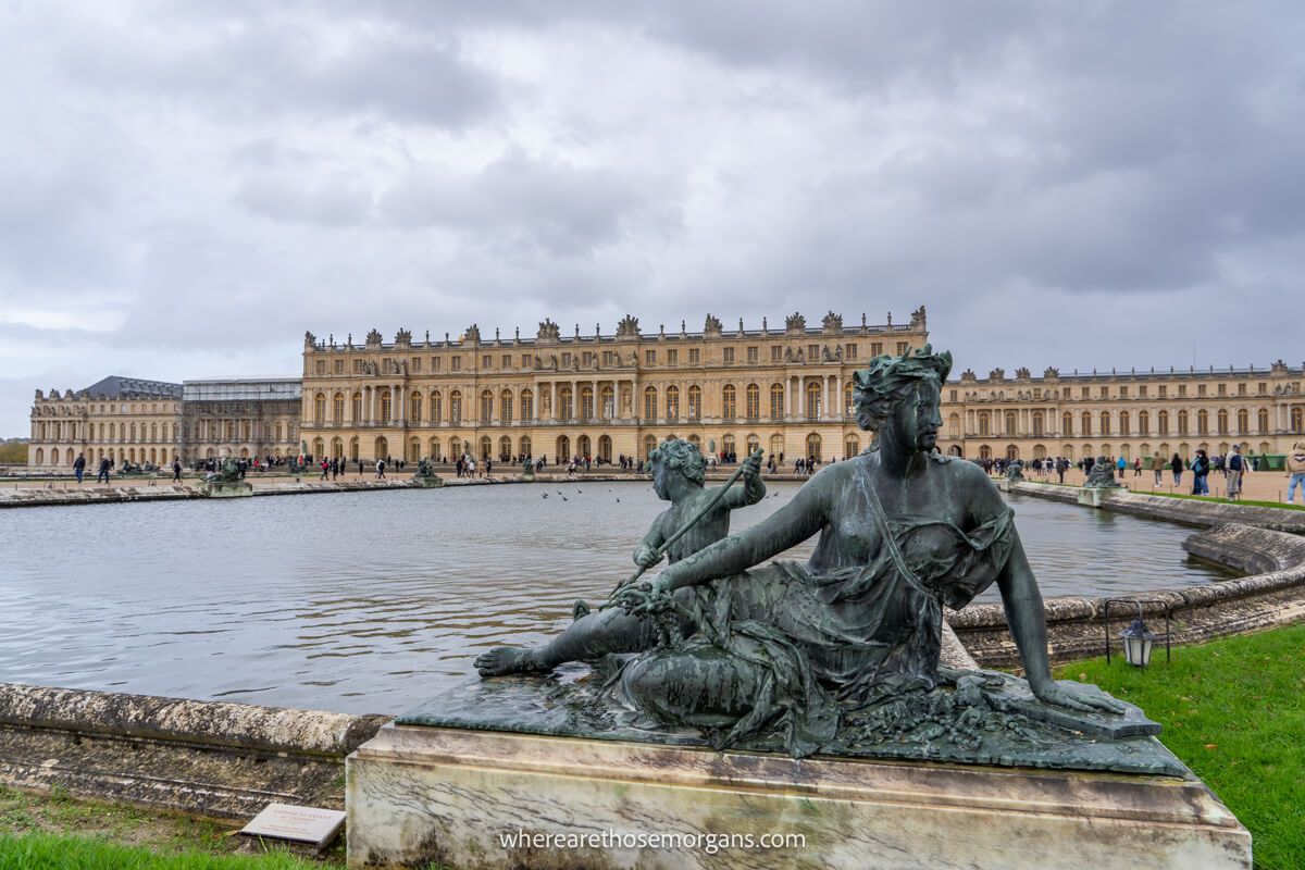 Statues along a large pond outside the Palace of Versailles