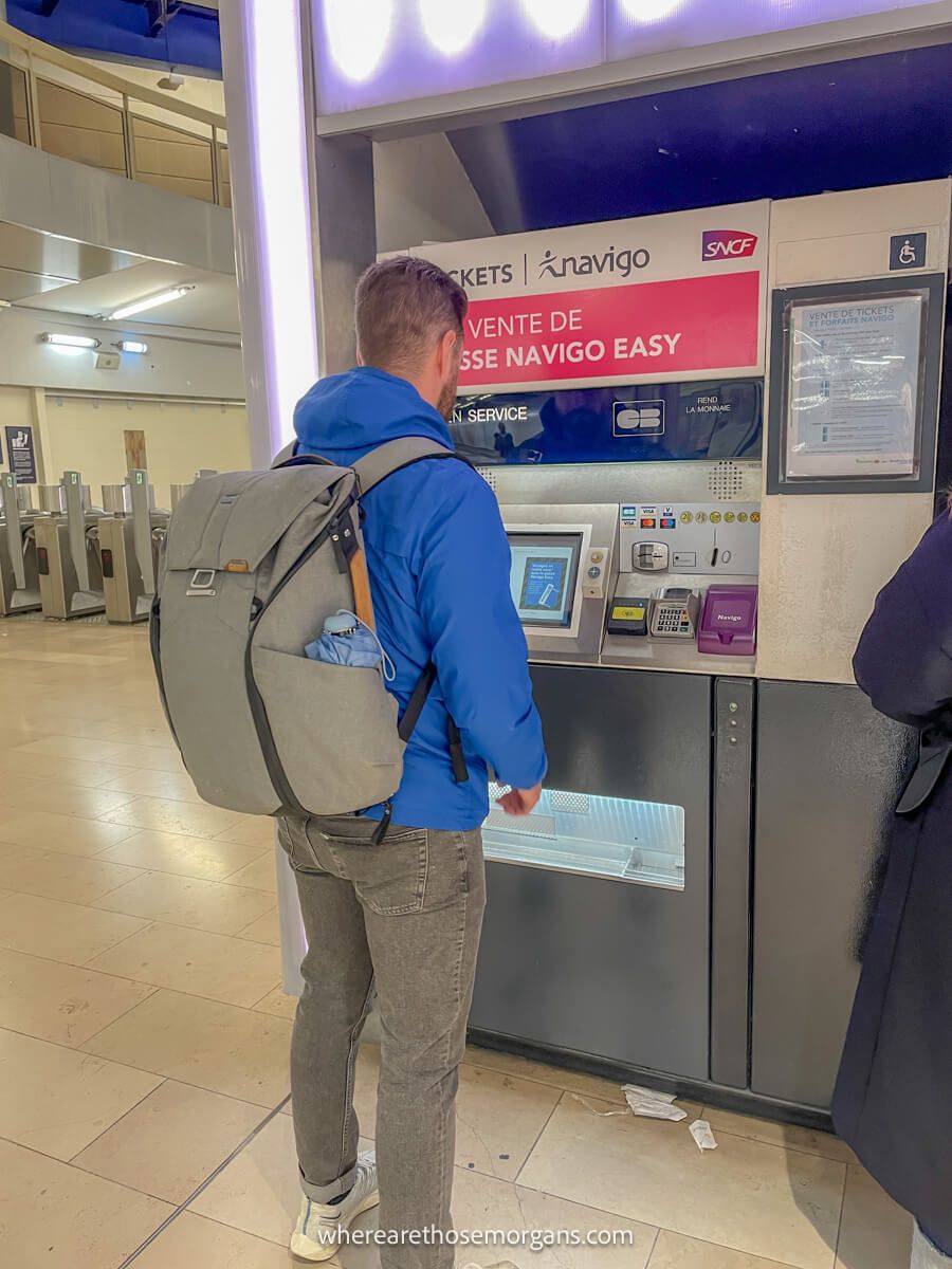 Man buying a train ticket at a paris train station