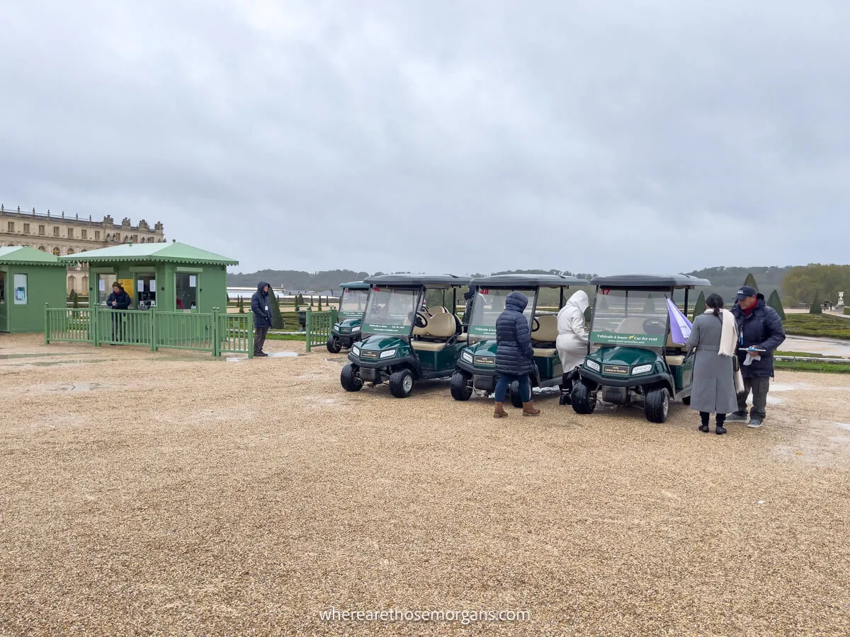 People using golf carts to get around versailles on a rainy day