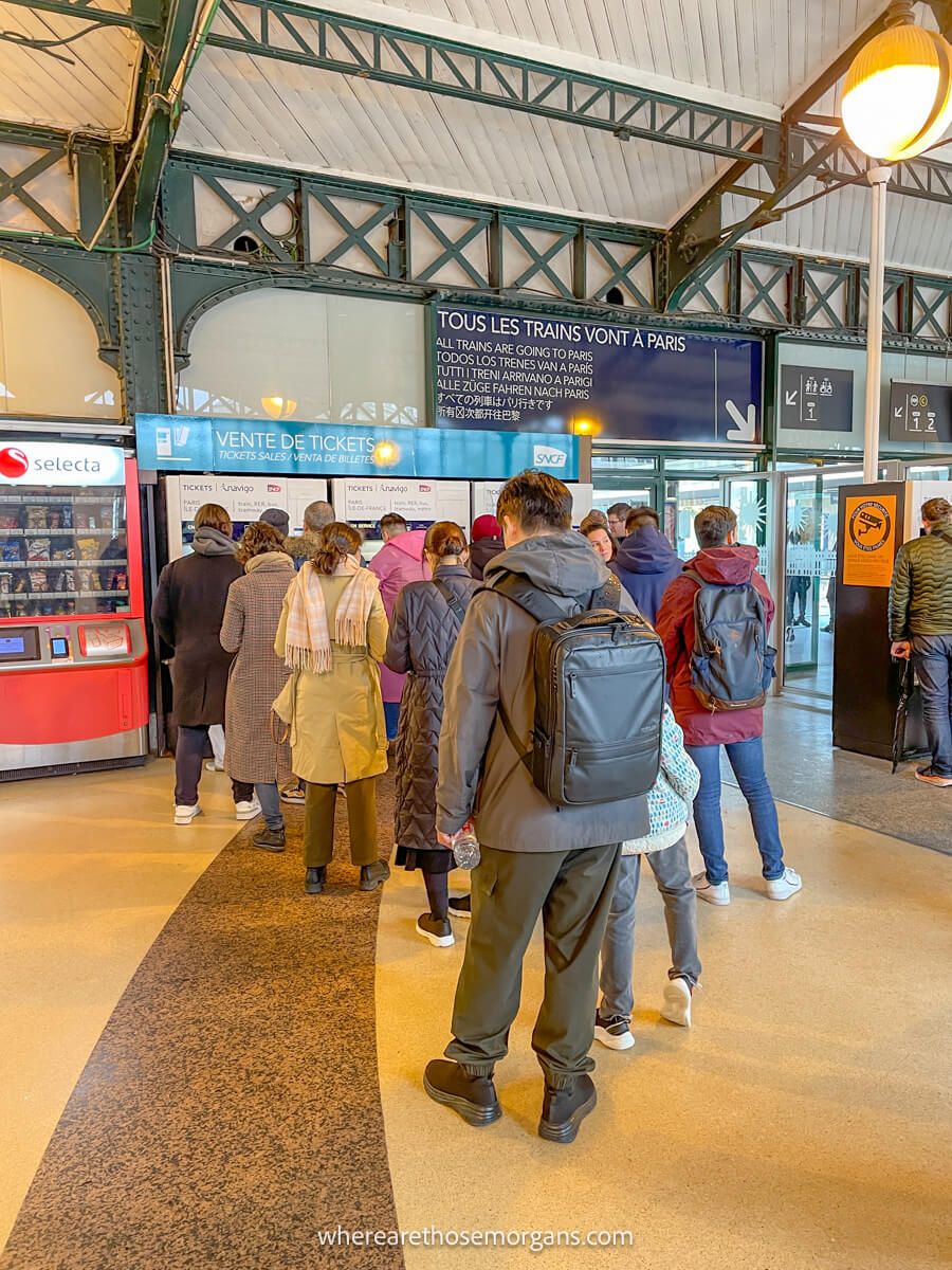Long line of tourists standing in line to purchase a ticket for the train back to paris from versailles