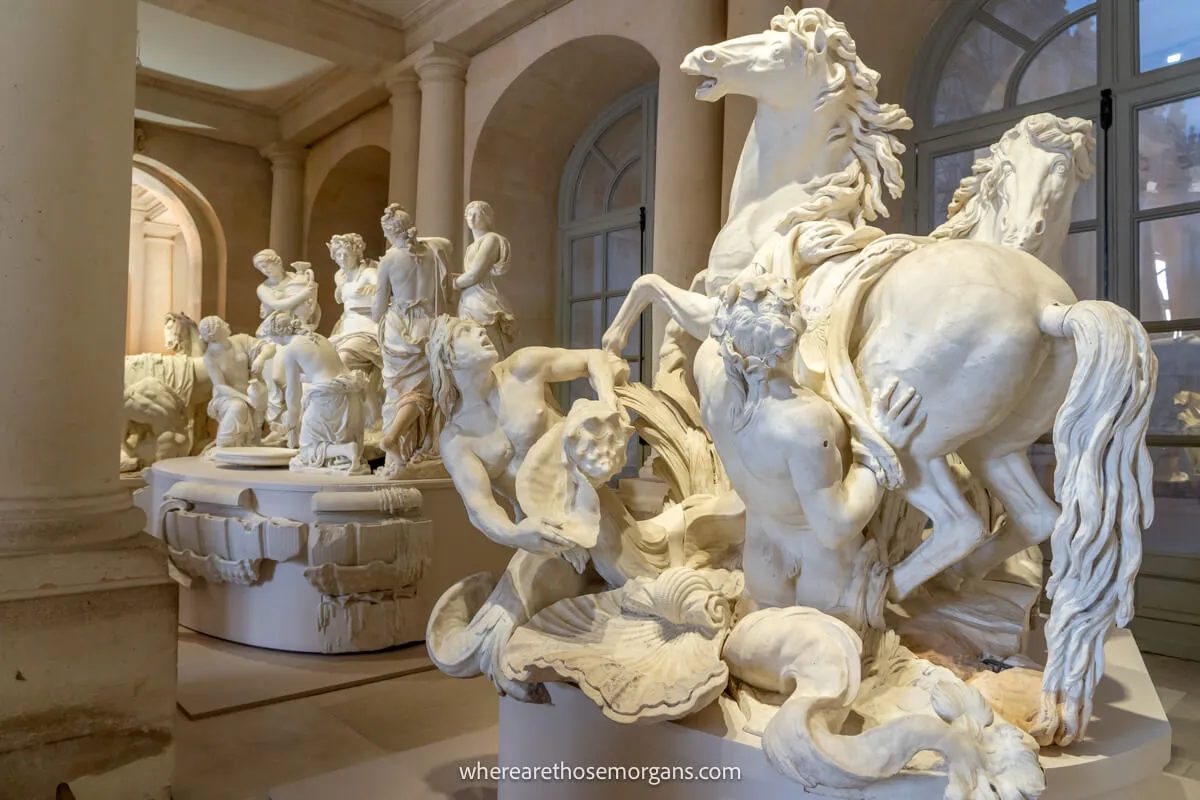 Large white and marble sculptures of men with horses