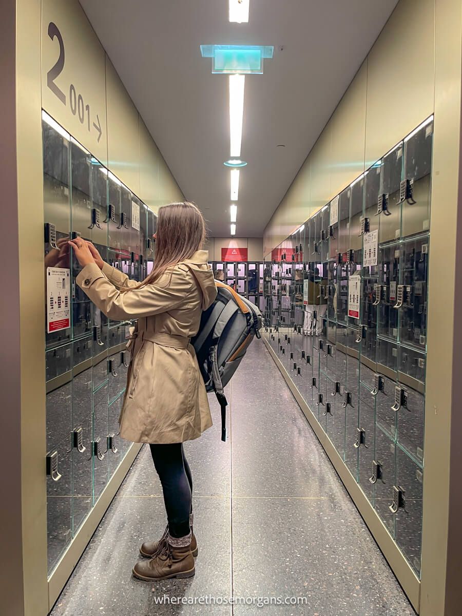 Woman putting her backpack into a security locker