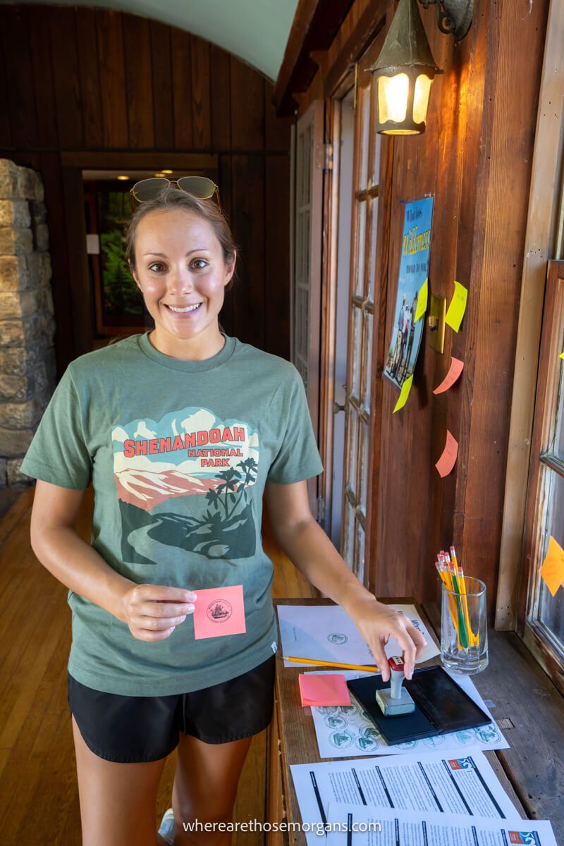 Woman stamping a national park passport book at Shenandoah