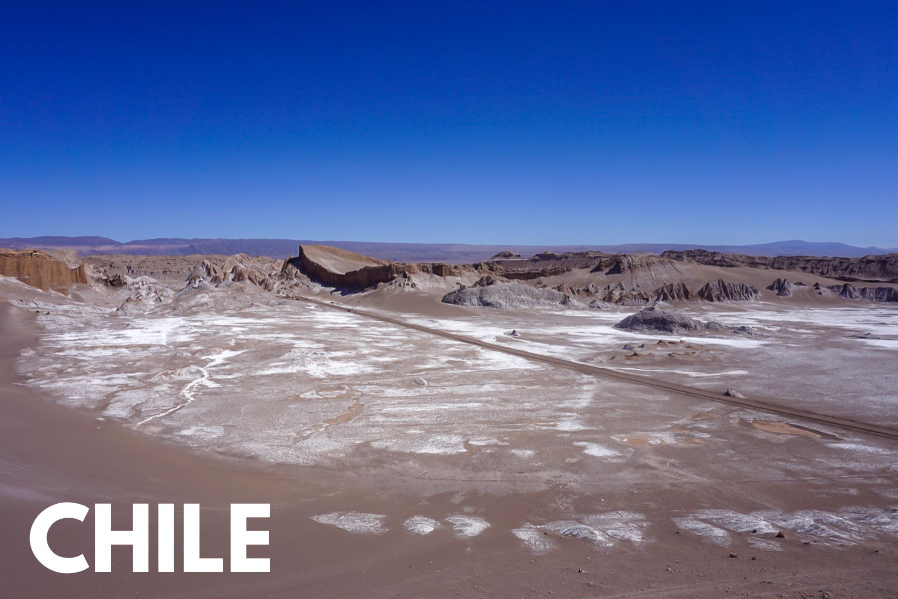 Photo of a barren desert with salt and bright sunshine in the Atacama Desert and the word Chile overlaid