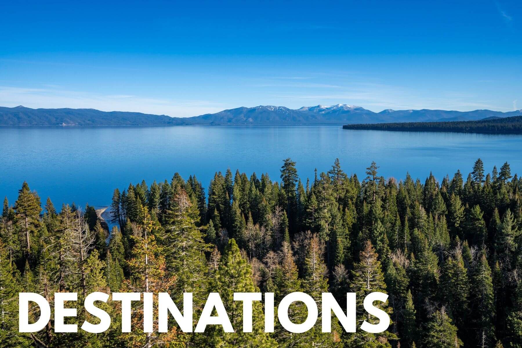 Photo of a view looking at the tops of trees leading to a lake and mountains in the distance with the word Destinations overlaid