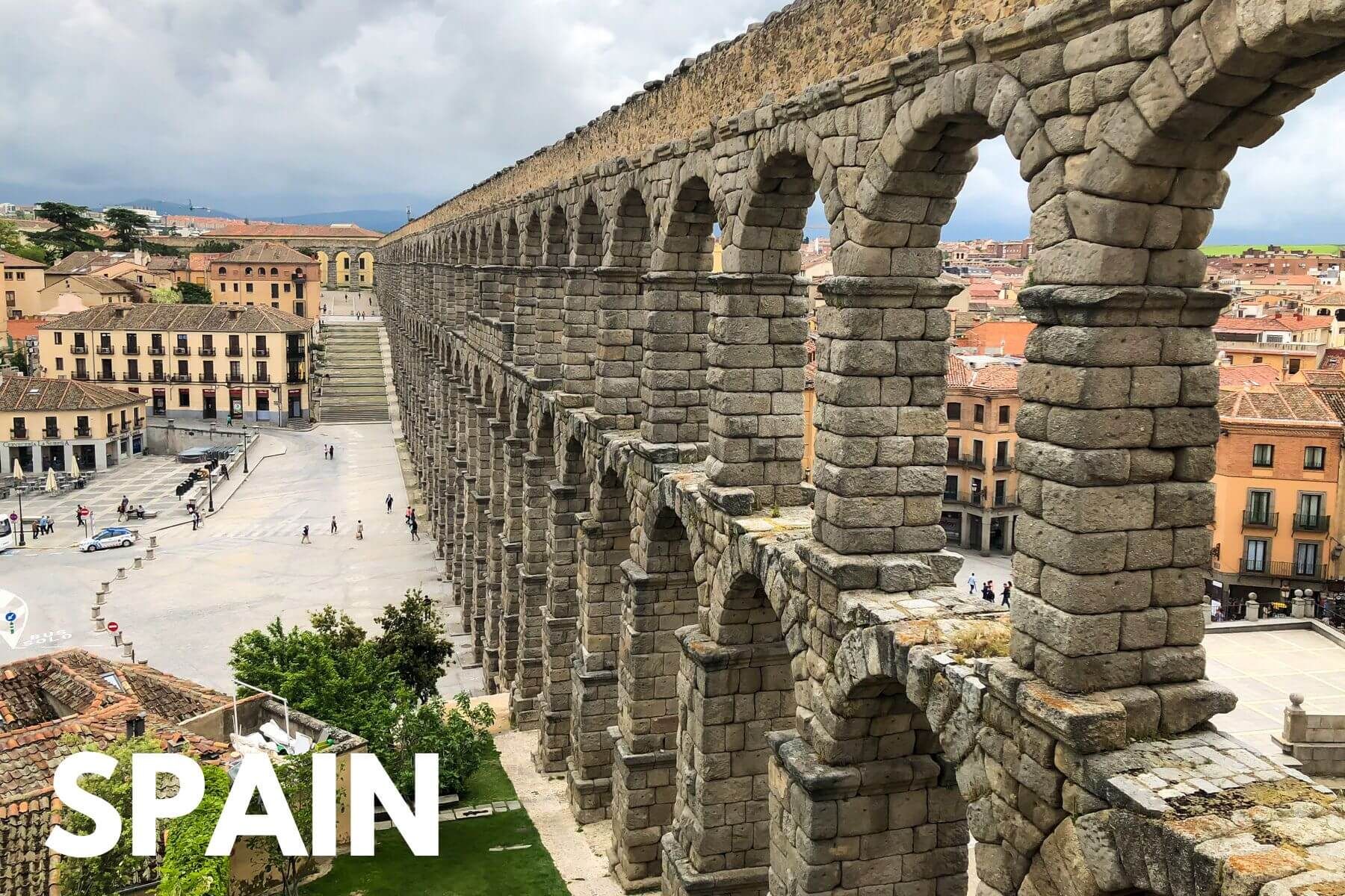 Photo of a stone viaduct running through a small town near Madrid with the word Spain overlaid