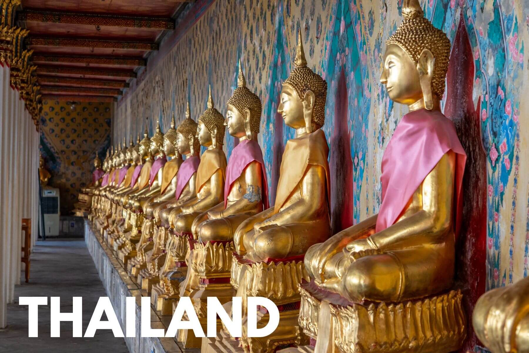Photo of a row of seated golden statues in a hall with the word Thailand overlaid