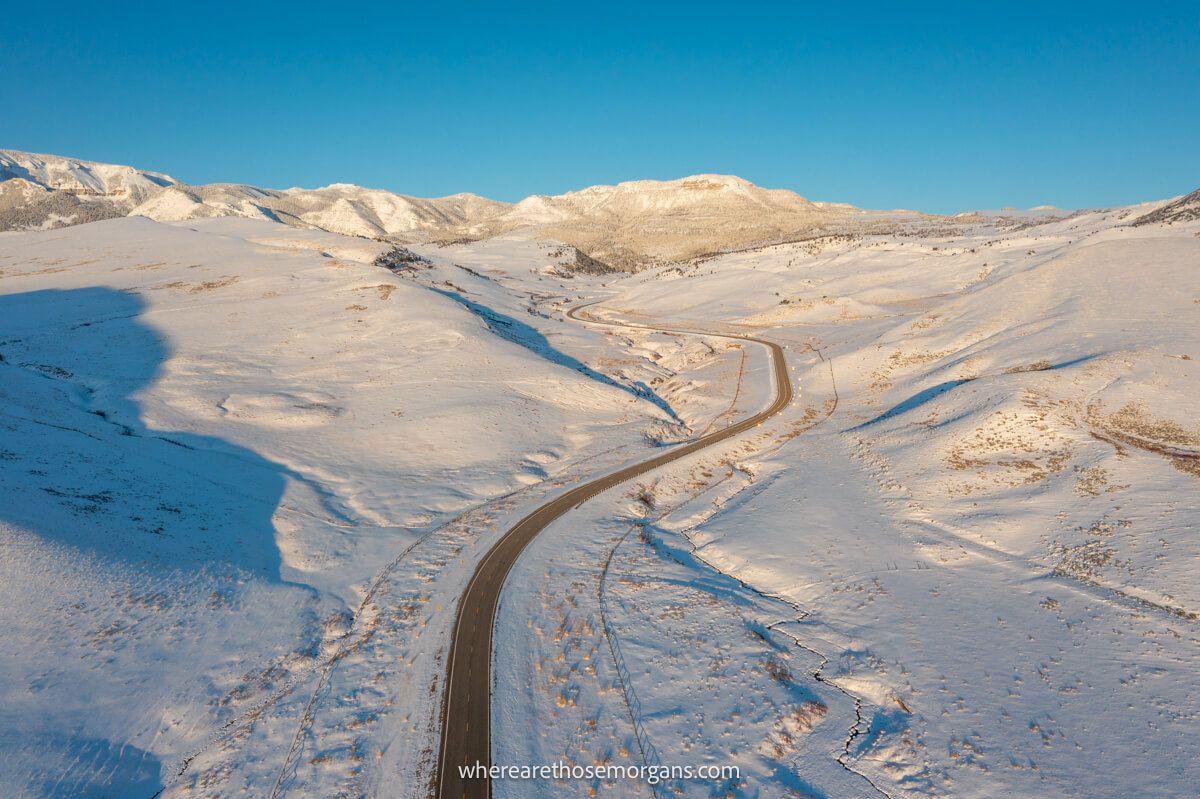 Drone shot of a snowy section of road leading to Yellowstone National Park
