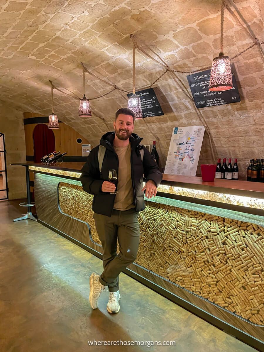 Tourist enjoying a glass of wine on a tour through the Les Caves du Louvre