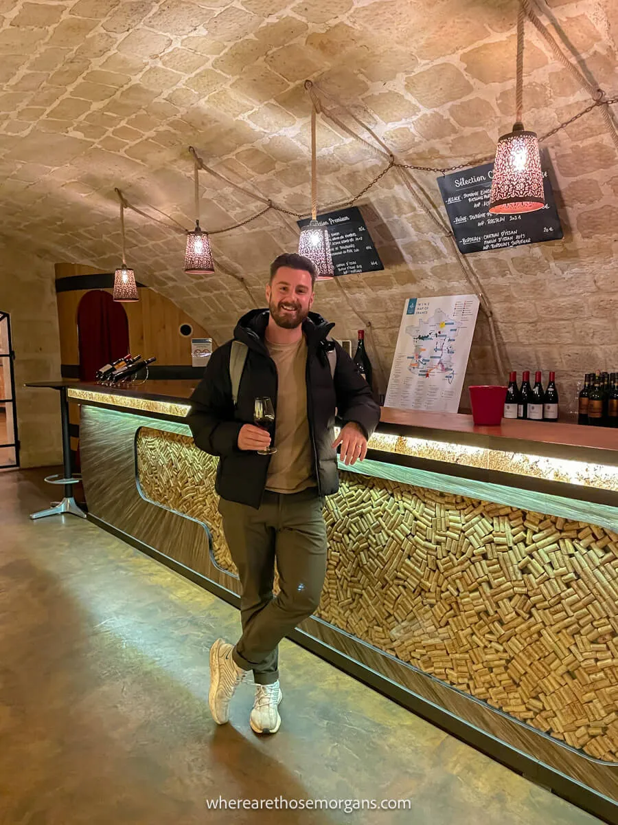 Tourist enjoying a glass of wine on a tour through the Les Caves du Louvre