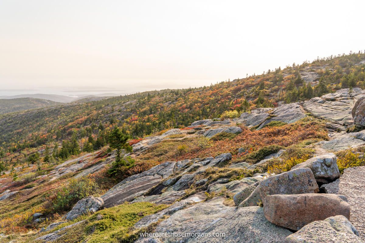 A rocky section of a hiking trail with stunning fall foliage