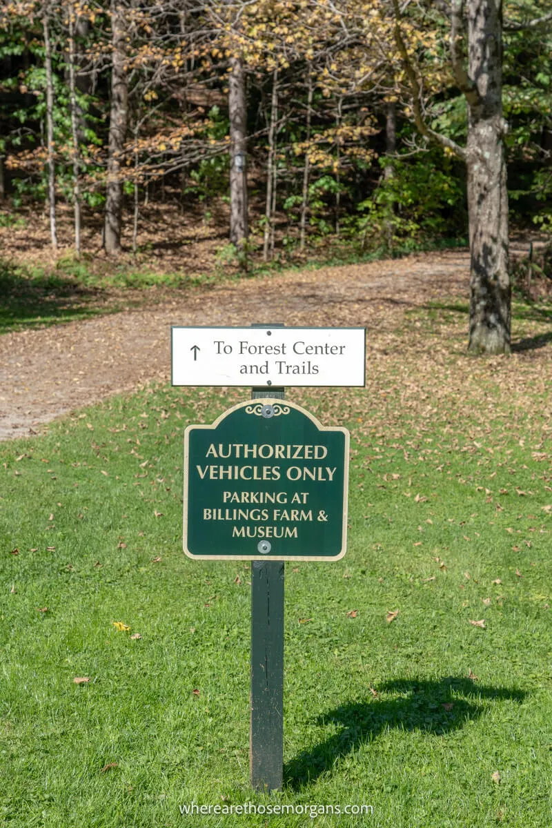 A green and white sign pointing to the hiking trails near Woodstock