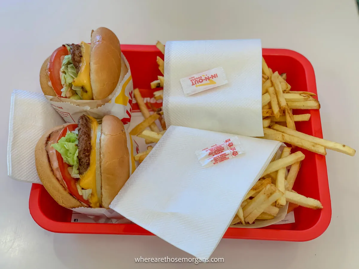 Two burgers and fries from In and Out on a red tray