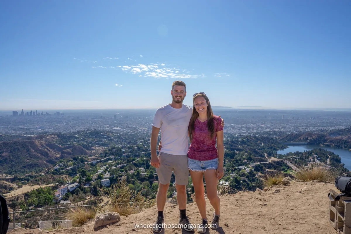 Two tourists posing for a photo near the Hollywood Sign in Los Angeles, California