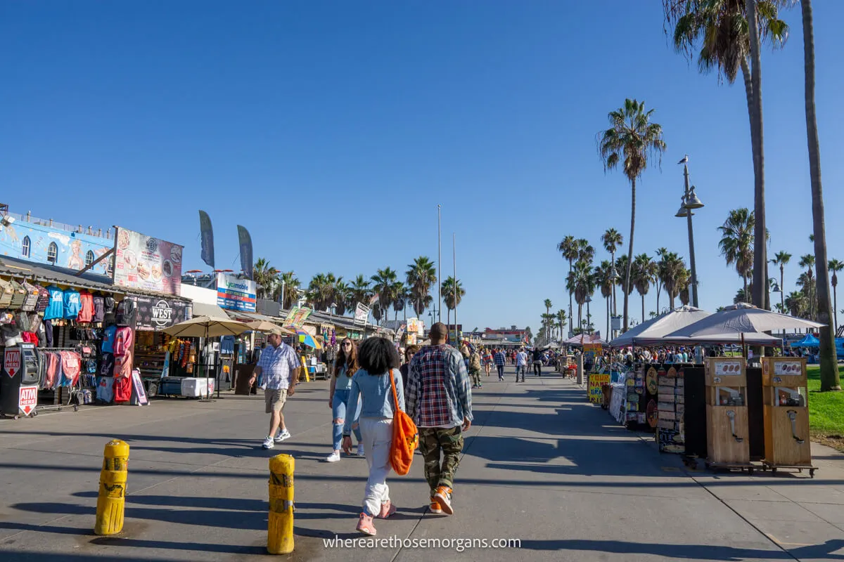 Tourists walking along the boardwalk at Venice Beach in Los Angeles, California