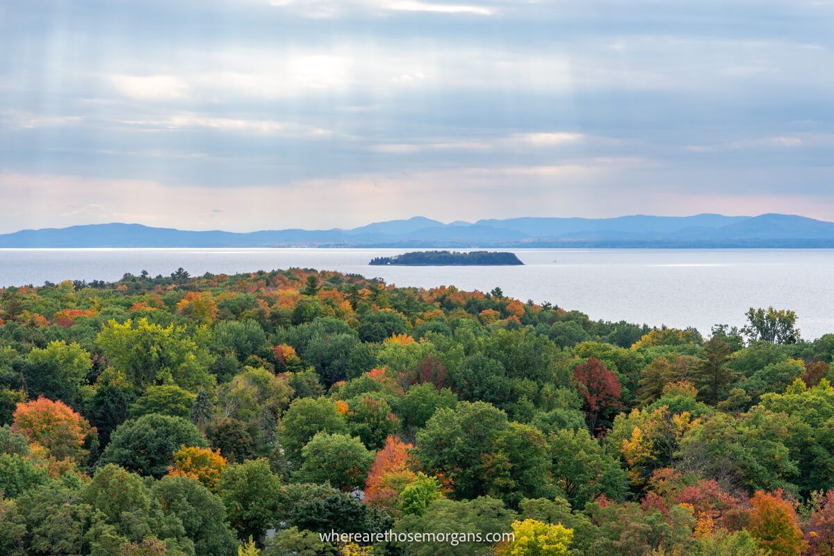 The sun shining on Lake Champlain with mountain views in the distance