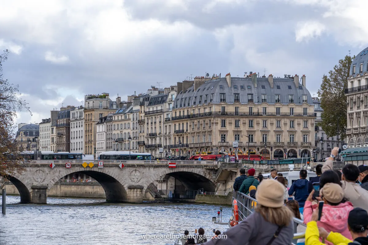 Numerous visitors taking photos of the famous landmarks on a boat cruise in Paris