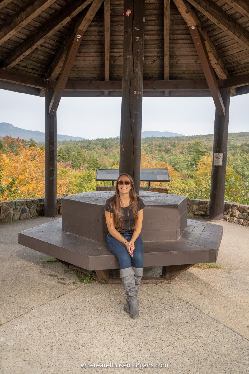 Tourist sat inside a wooden pavilion with views over rolling hills behind