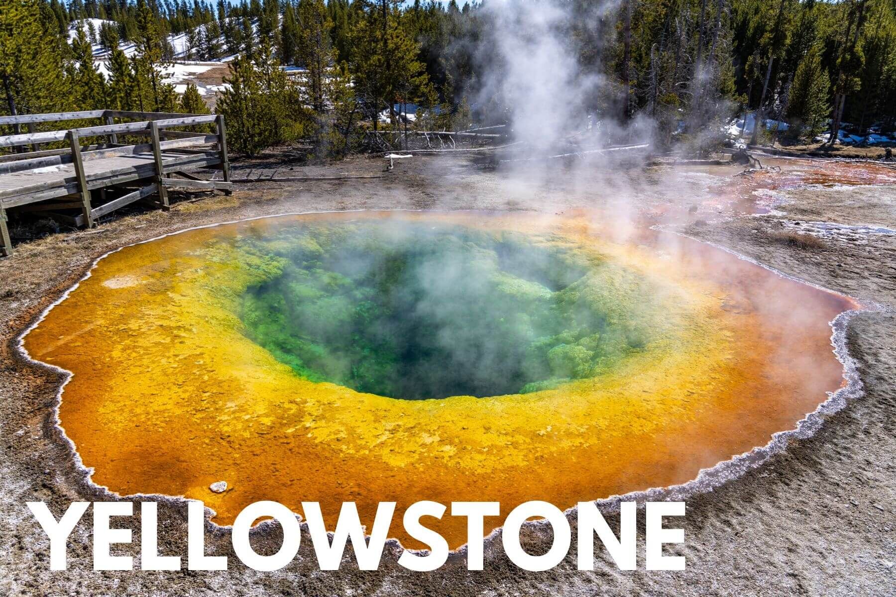 Photo of a vibrant hot spring in Yellowstone National Park with bright orange, yellow, green and blue colors, along with a small amount of billowing steam