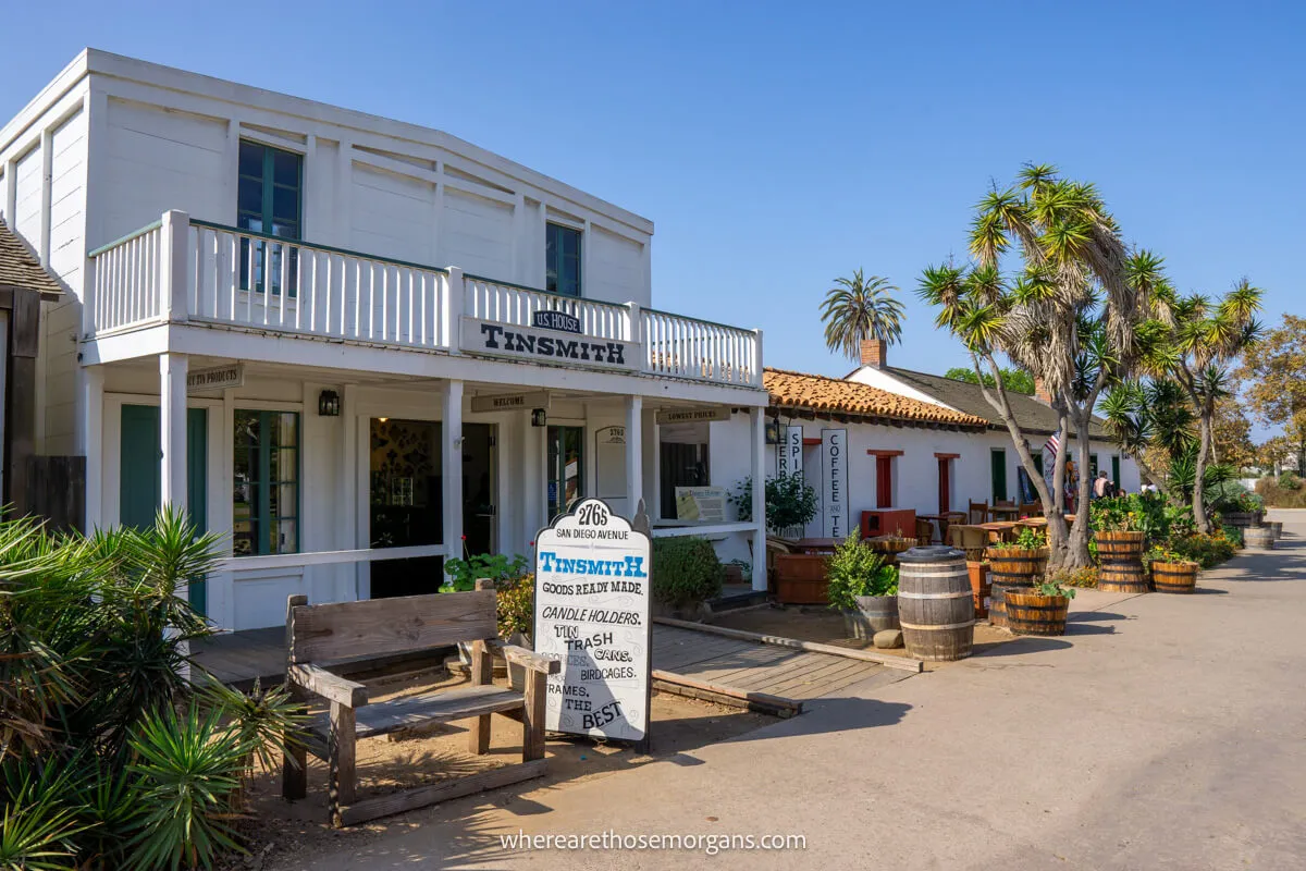 Historic wooden buildings in a row next to a road with a clear blue sky at Old Town San Diego