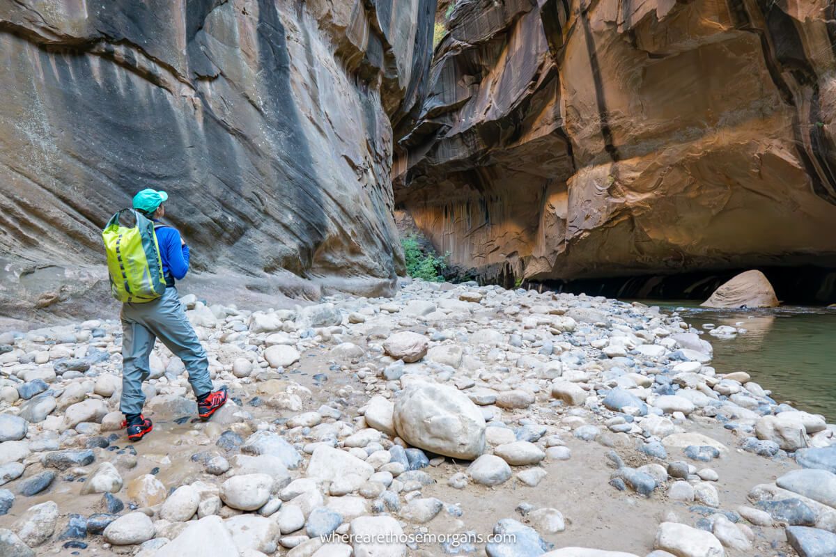 Photo of a hiker in waterproofs hiking The Narrows in Zion in winter