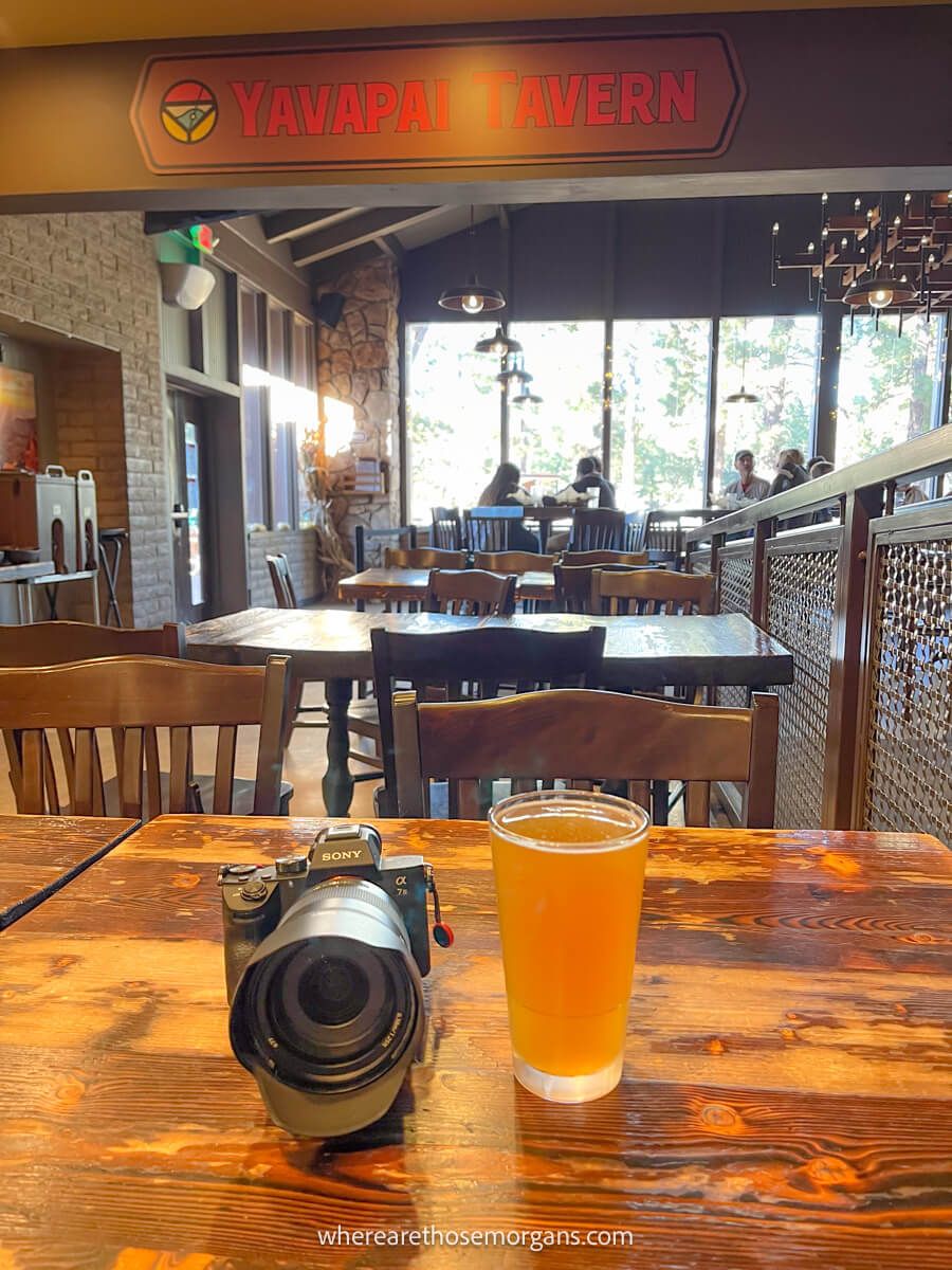 Photo of a camera and beer on a wooden table in a restaurant called Yavapai Tavern