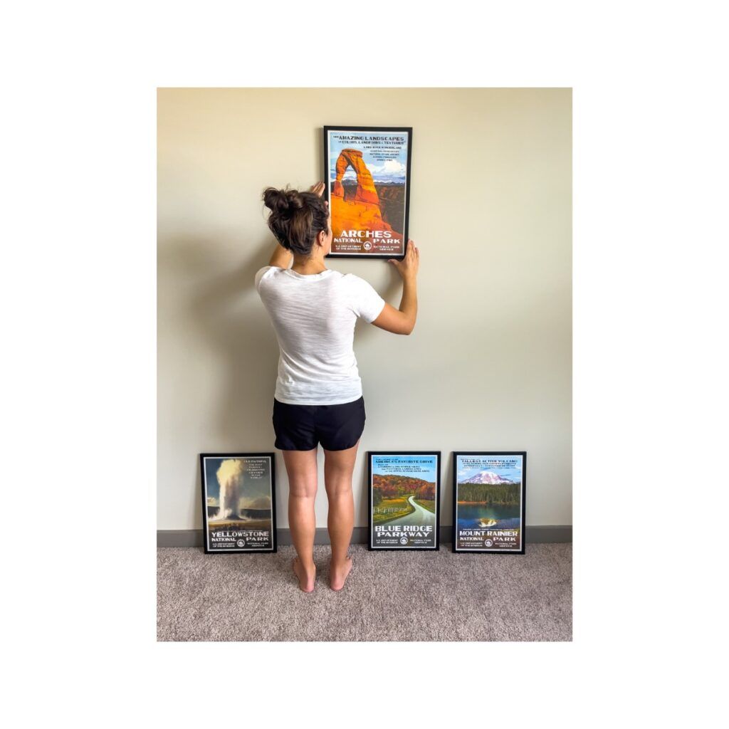 Woman hanging multiple national park posters