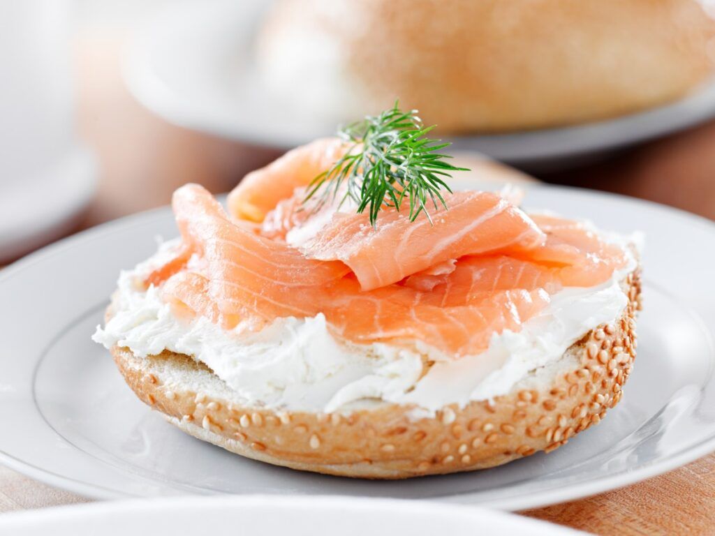 Smoked fish and cream cheese on top of the sesame bagel