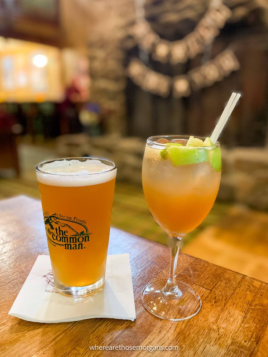 Glass of beer and a cocktail next to each other on a table inside a classy pub