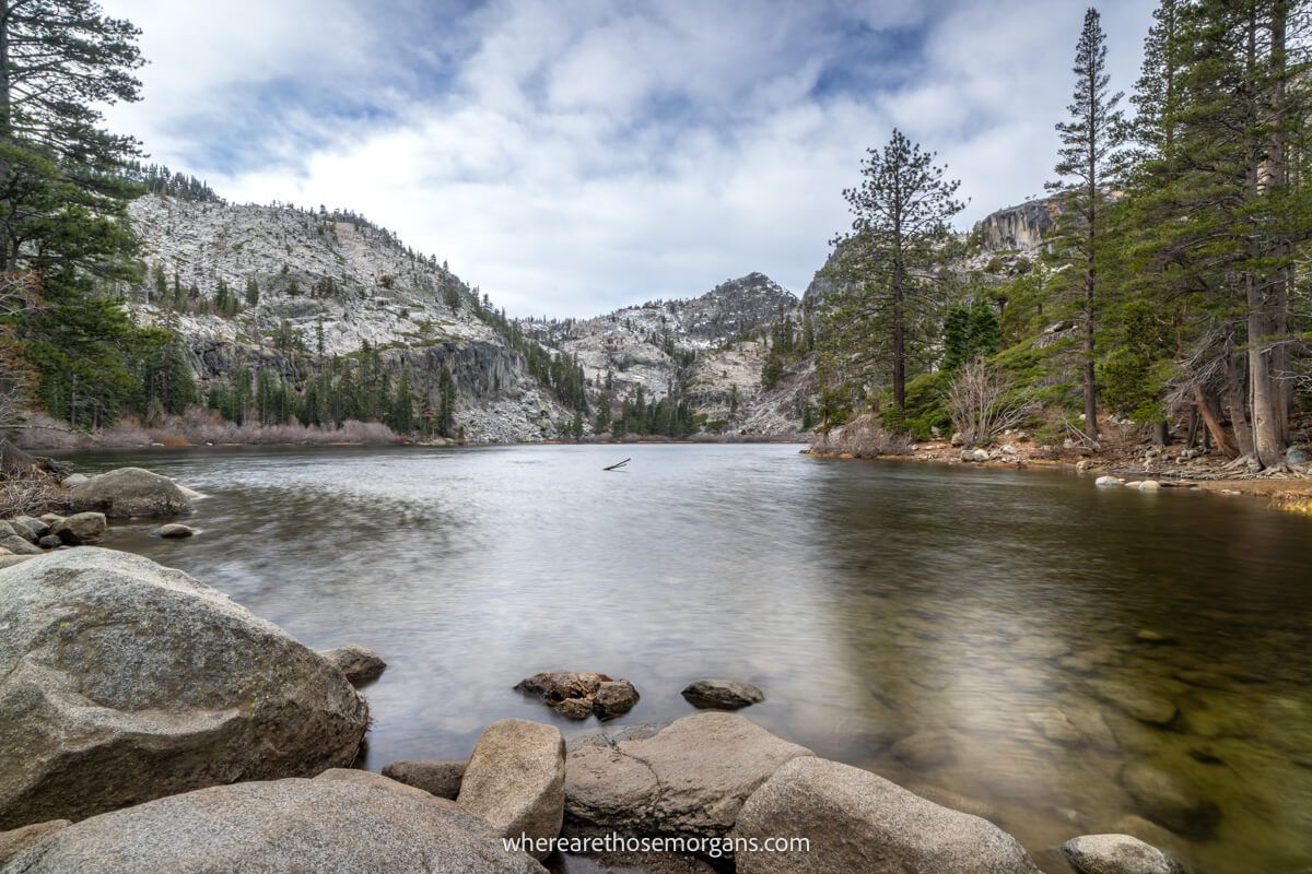 Photo of Eagle Lake in Lake Tahoe taken early in the morning on a cloudy day with rocks in the foreground and no people in sight