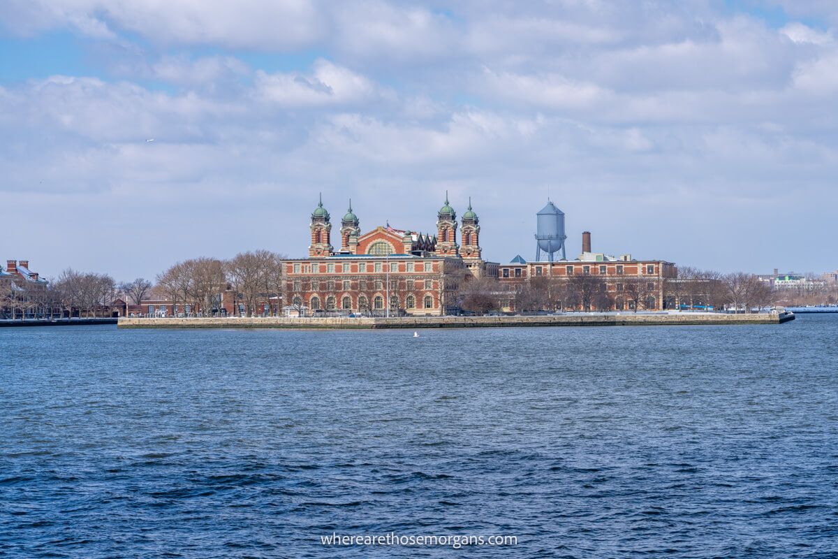 Photo of Ellis Island from across the water on a clear day with light clouds