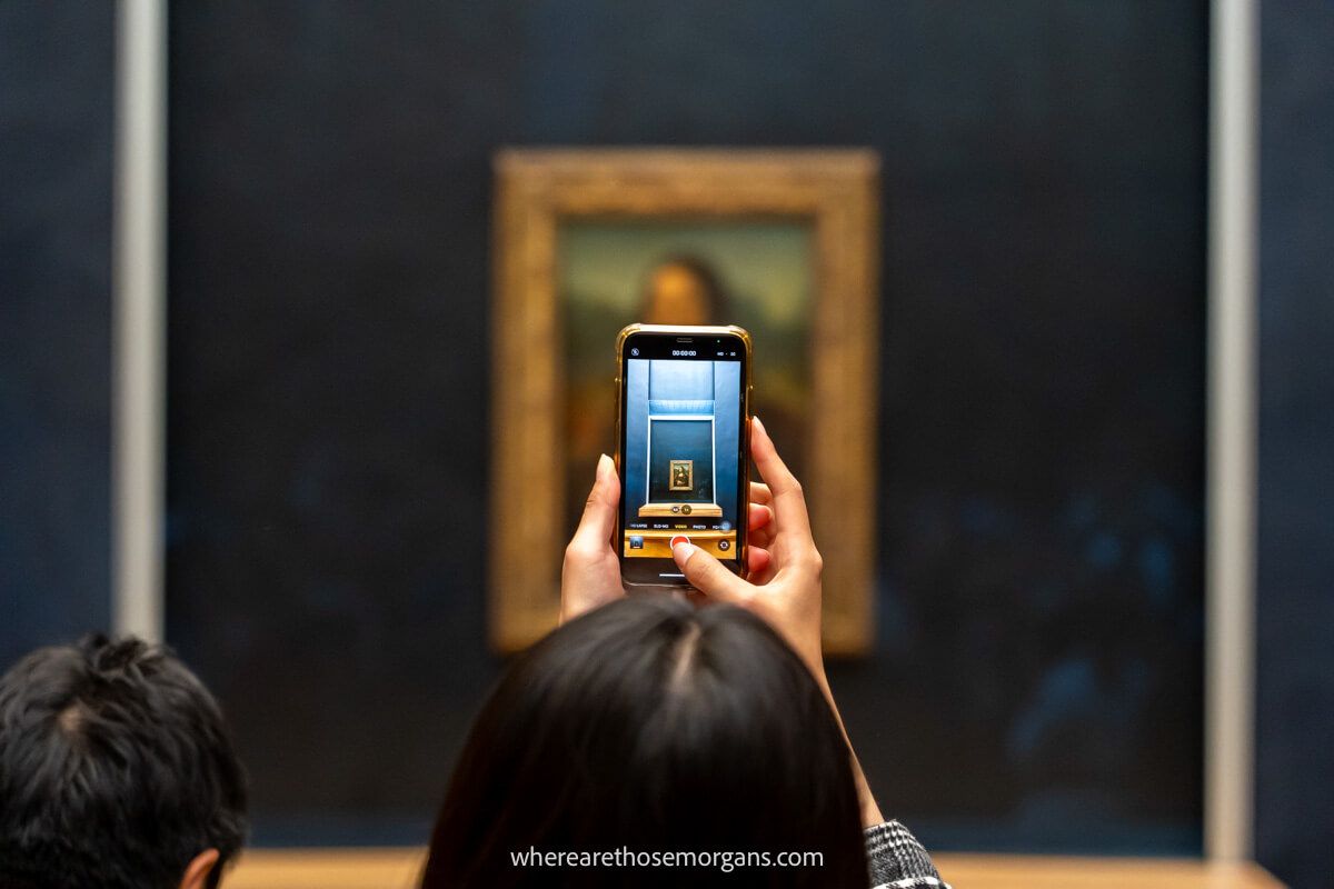 Photo of a smartphone taking a photo of the Mona Lisa in The Louvre Museum